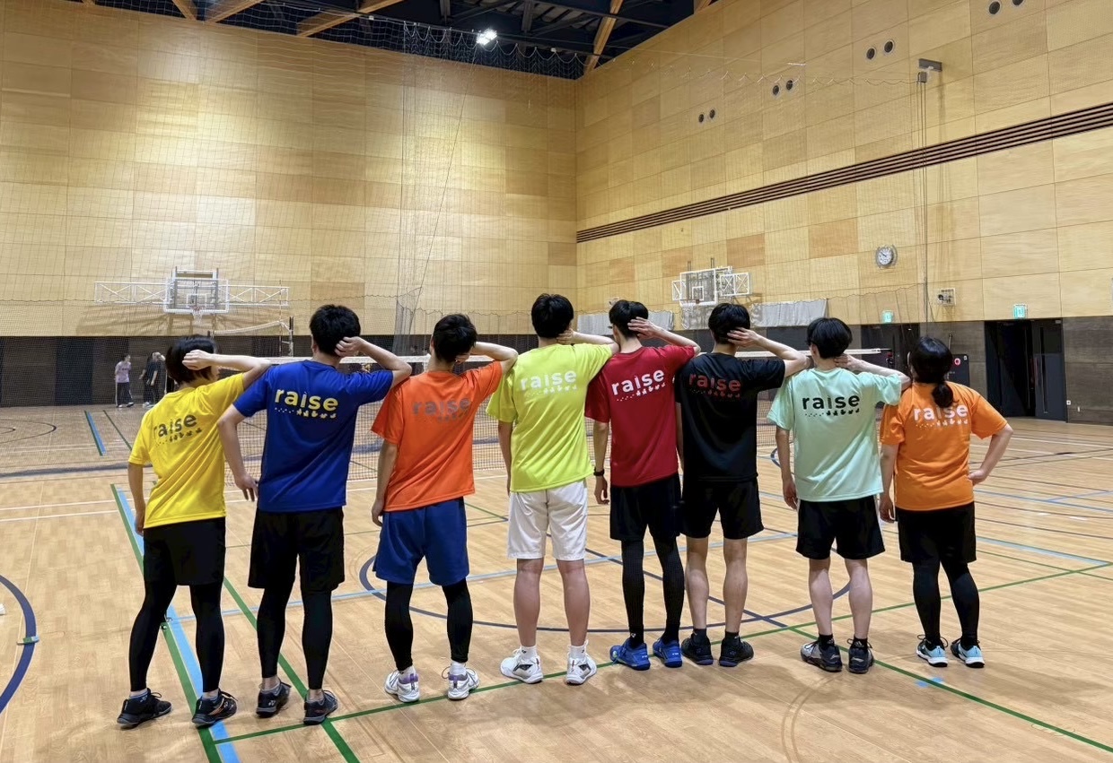 お揃いのチームTシャツで肩を組む raise のメンバー